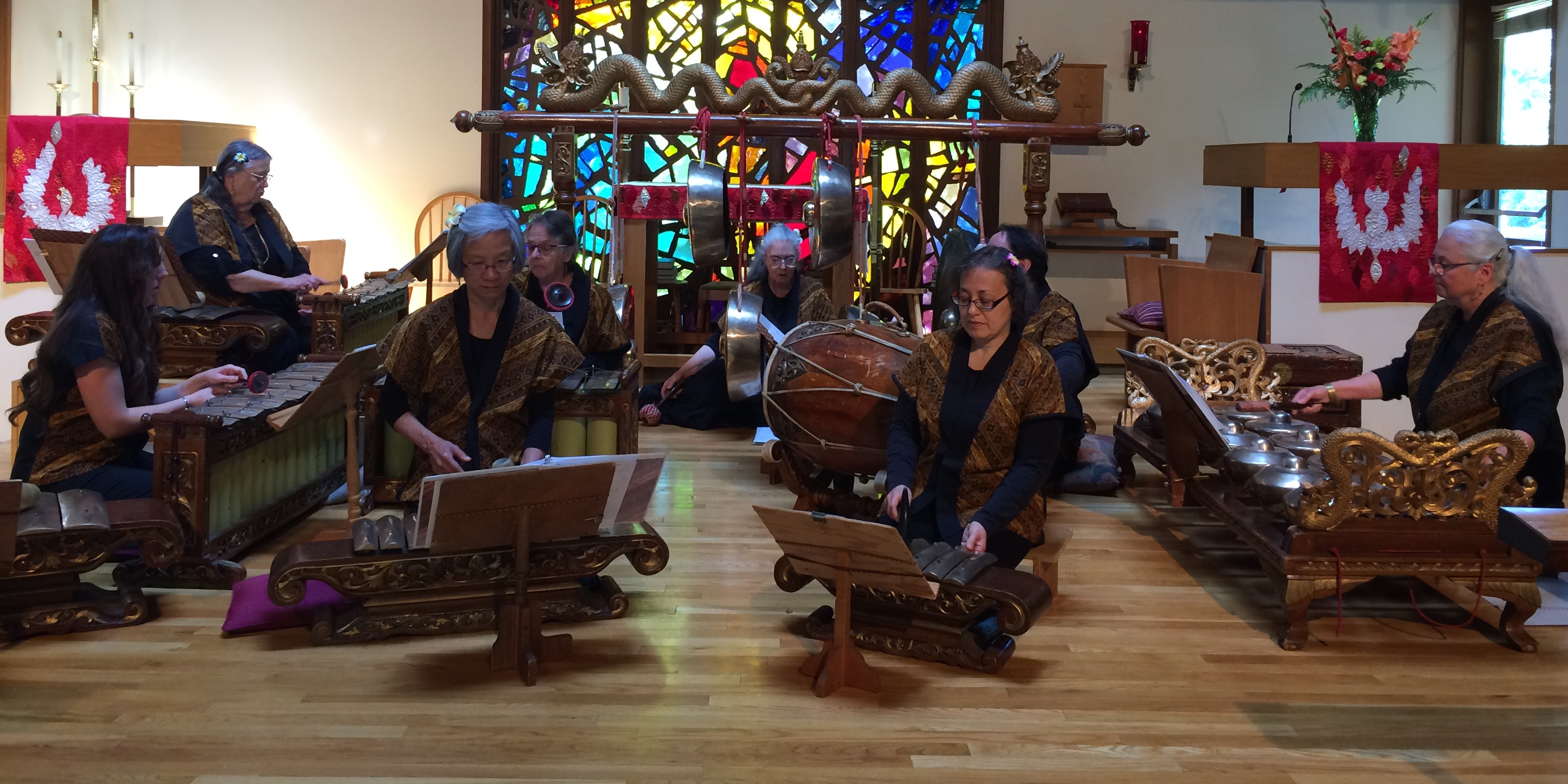 The ensemble performing live in front of stained glass