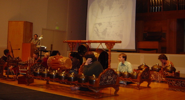 Gamelan prepares to play at a school assembly while an administrator speaks