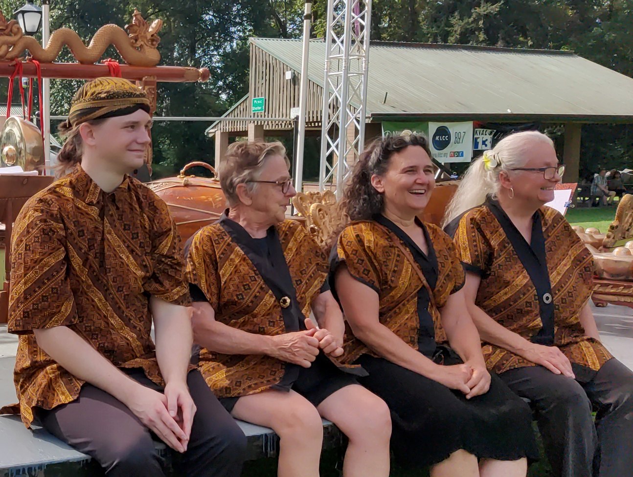 A puppetmaster performs behind the stage while the gamelan performs